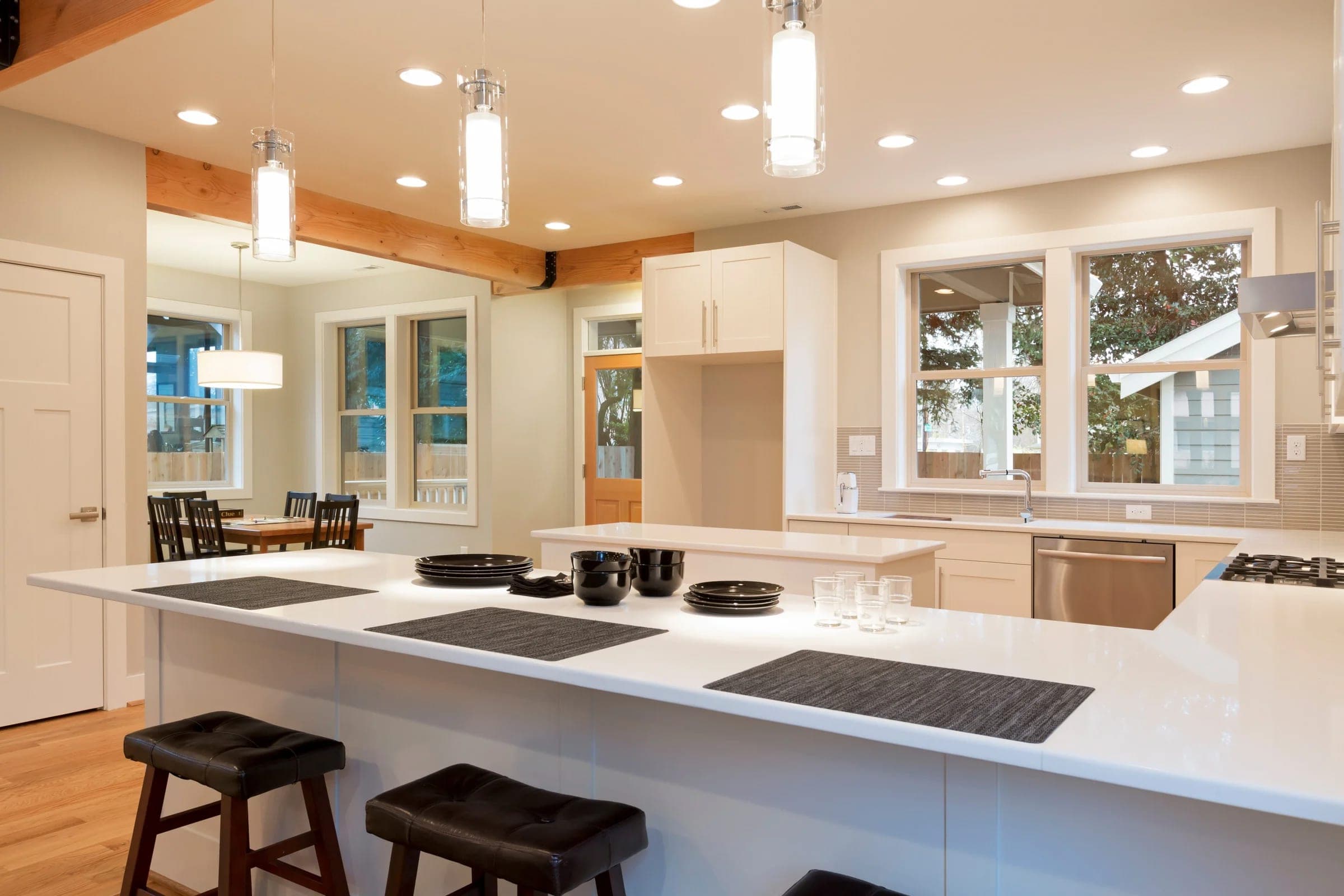 Modern white kitchen renovation concept with waterfall island and pendant lighting